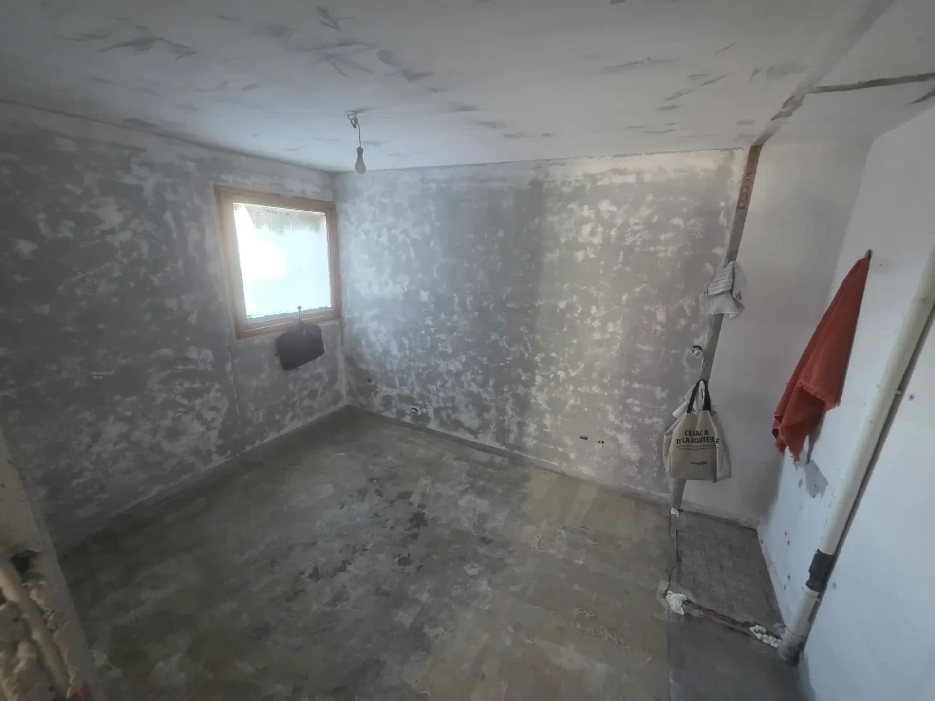 Chambre en rénovation avec murs à nu, fenêtre, plafond fissuré à Méribel