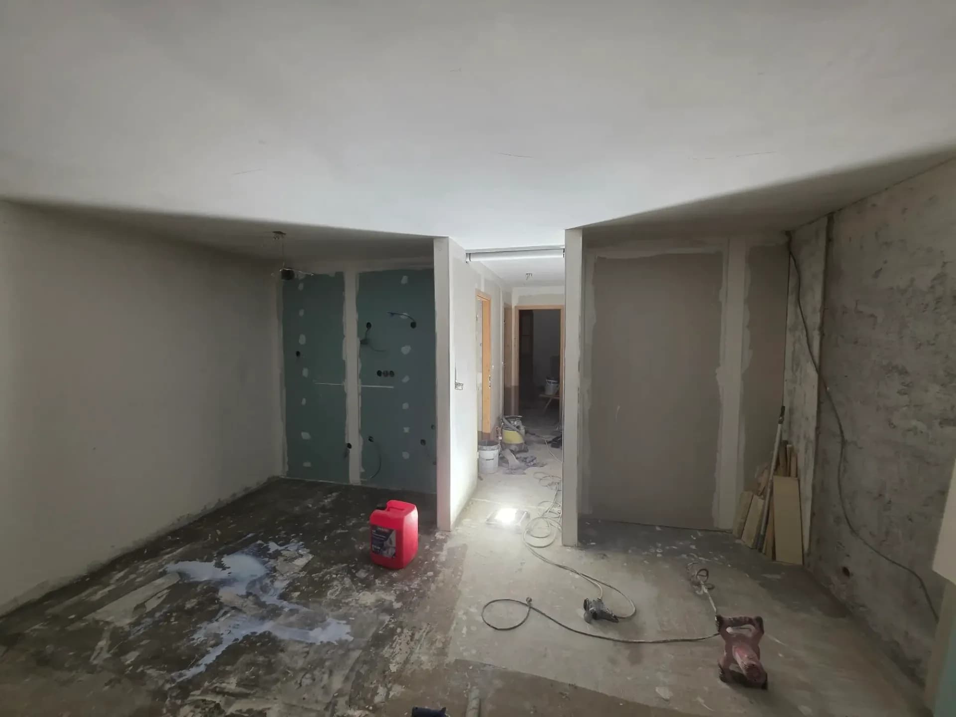Salon et partie cuisine en rénovation dans ce logement de Méribel, murs enduits, cloisn de doublage de la cuisine.
