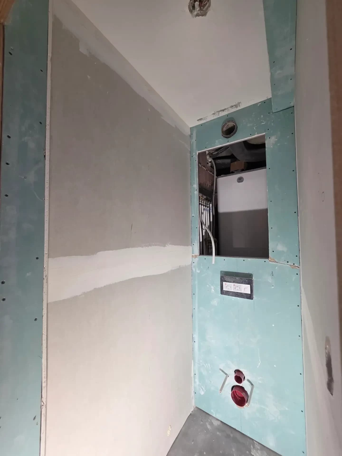 Cloison en plaques de plâtre hydrofuges dans le wc, plaquage du bâti-support.