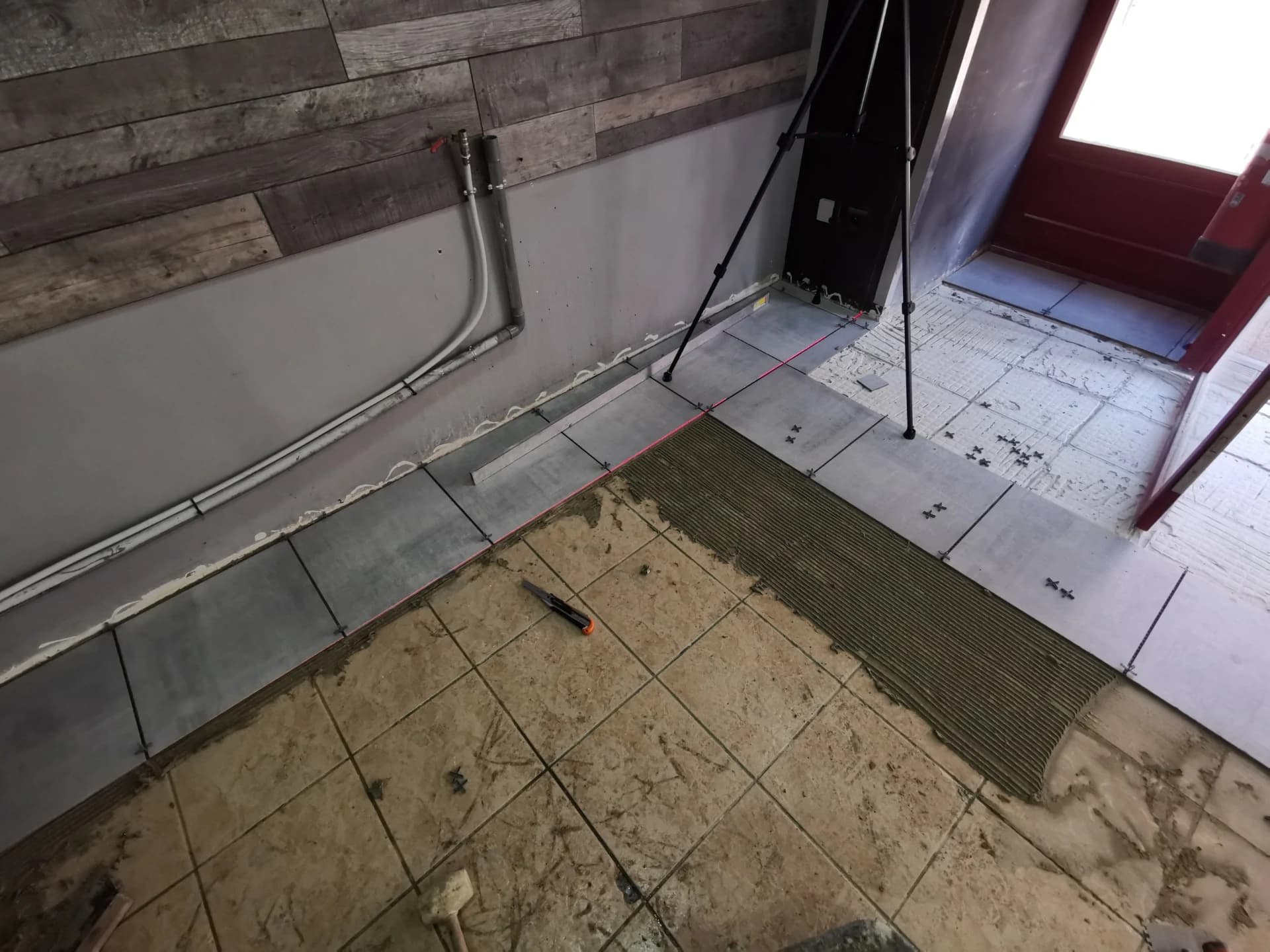 Un primaire d'accroche est appliqué au rouleau sur l'ensemble de la surface à carreler
