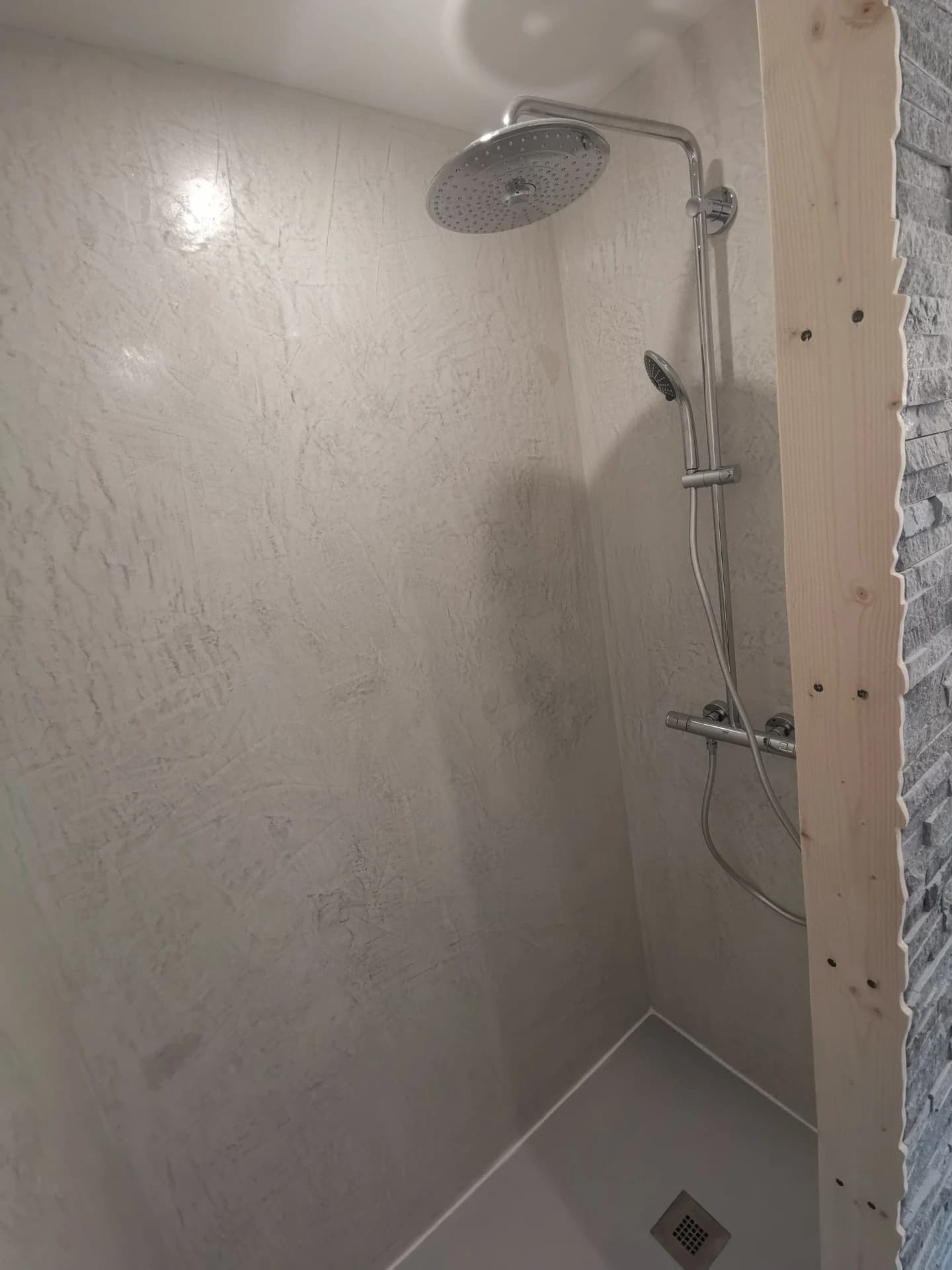 Une planche de bois tablettée aux formes du parement est posée. Pose de la colonne de douche