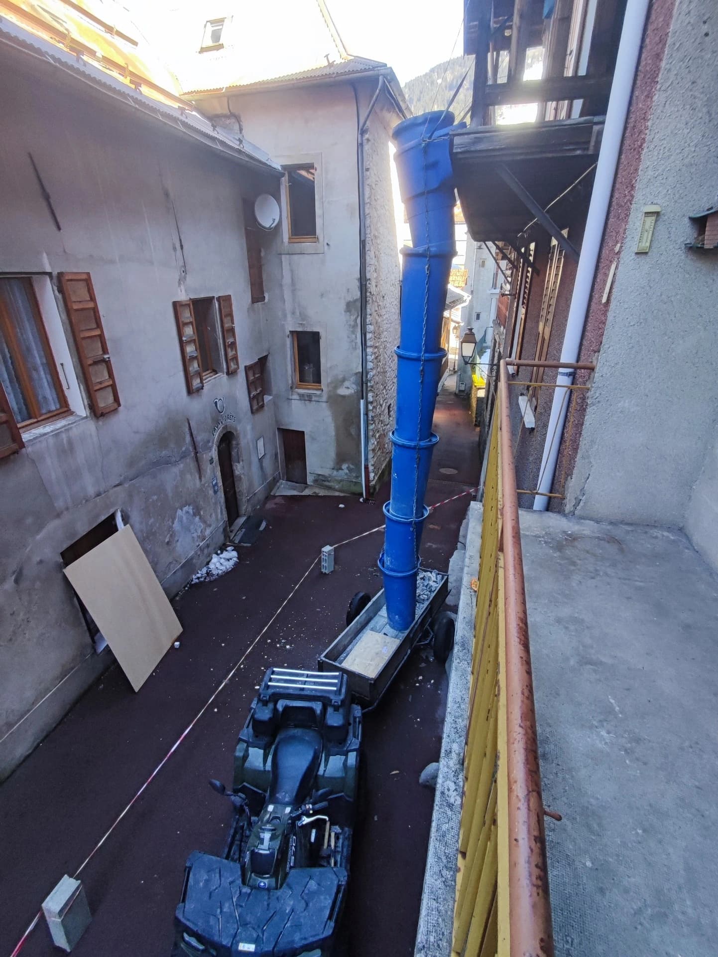 Installation du tunnel de chantier, seul le quad et la remorque passent dans la ruelle étroite