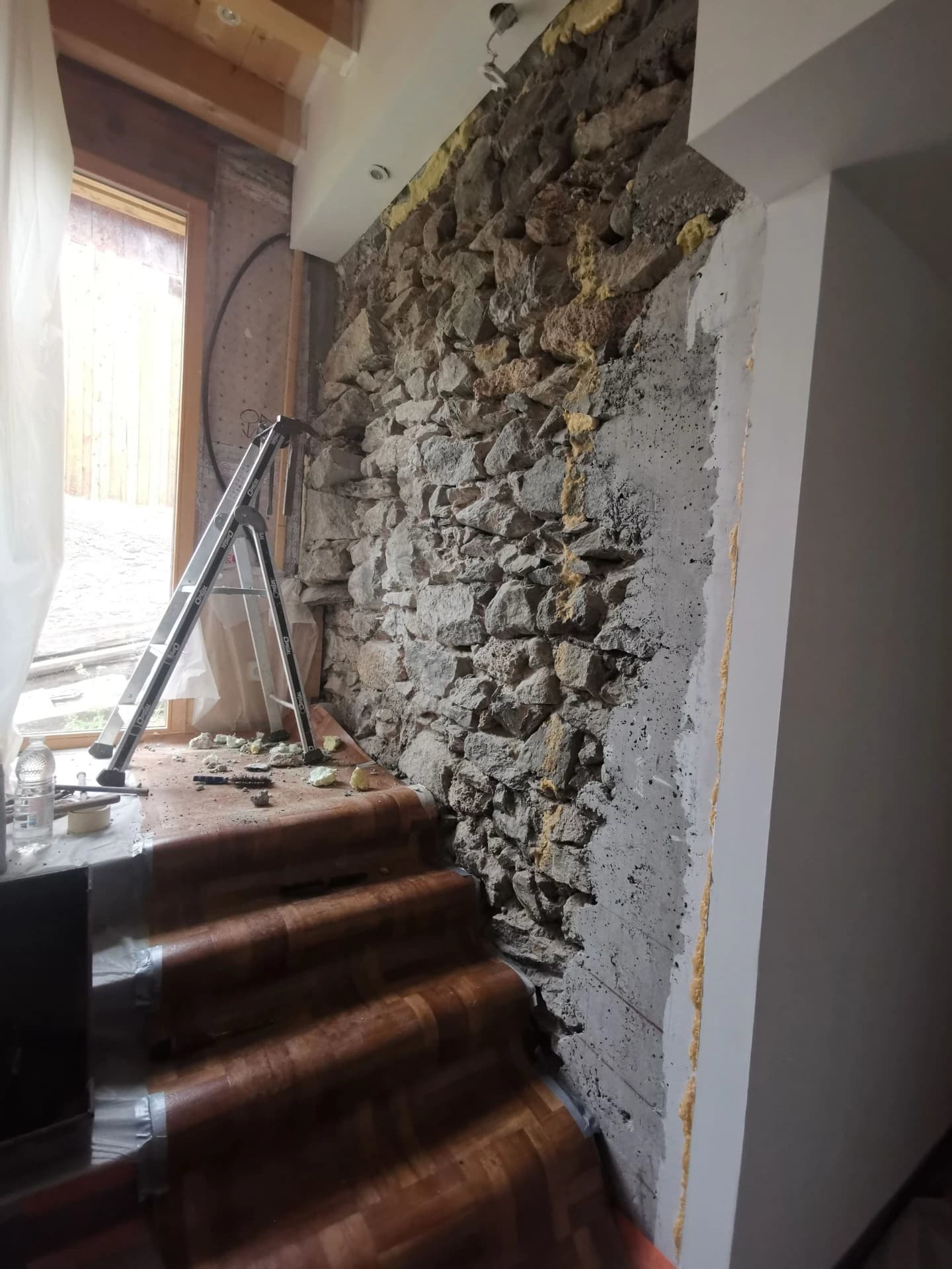 Joints chaux et habillage bois sur un mur en pierre à Celliers